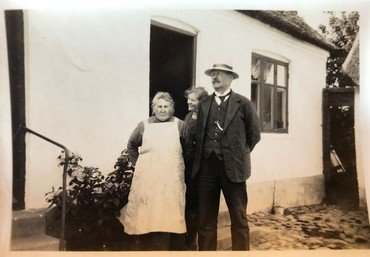 Kirstine og Henrik på gårdspladsen sammen med datteren Olga. Kirstine døde 28.2. 1929.